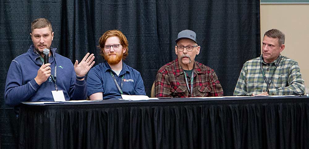 Desde la izquierda, los productores de peras Sam Parker, Chris Strohm, Mel Weythman y Keith Granger, hablan entre sí sobre el manejo integrado de plagas (MIP) en la reunión anual de la Asociación de Árboles Frutales del Estado de Washington (Washington State Tree Fruit Association, WSTFA) en Kennewick en diciembre pasado. (Ross Courtney/Good Fruit Grower)