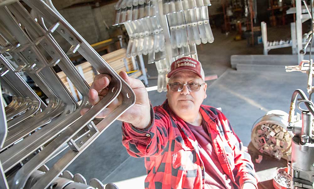 Richard Shenyer, propietario de Grandview Ladders en Washington, da forma y monta a mano los soportes superiores. La demanda de escaleras se ha mantenido estable a pesar del creciente uso de plataformas en los últimos 20 años, dijo. (Ross Courtney/Good Fruit Grower)