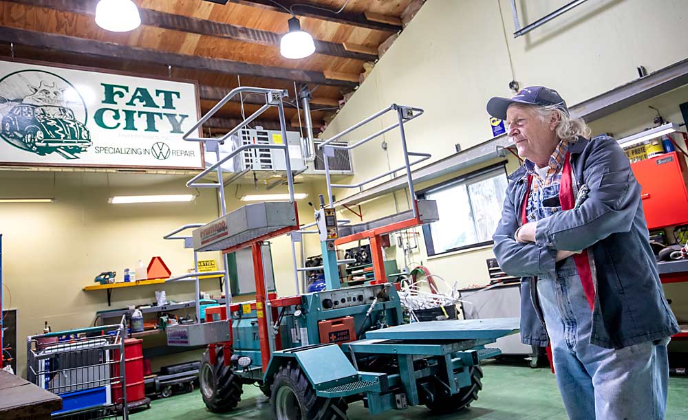 El copropietario de Sauk Farm, Jesse Berger, escucha a su hijo Griffin (no visto en la foto) hablar de la plataforma Tecnofruit CF-105, del fabricante alemán Frumaco, que la huerta utiliza para la poda, entrenamiento de las ramas y la cosecha. (TJ Mullinax/Good Fruit Grower)