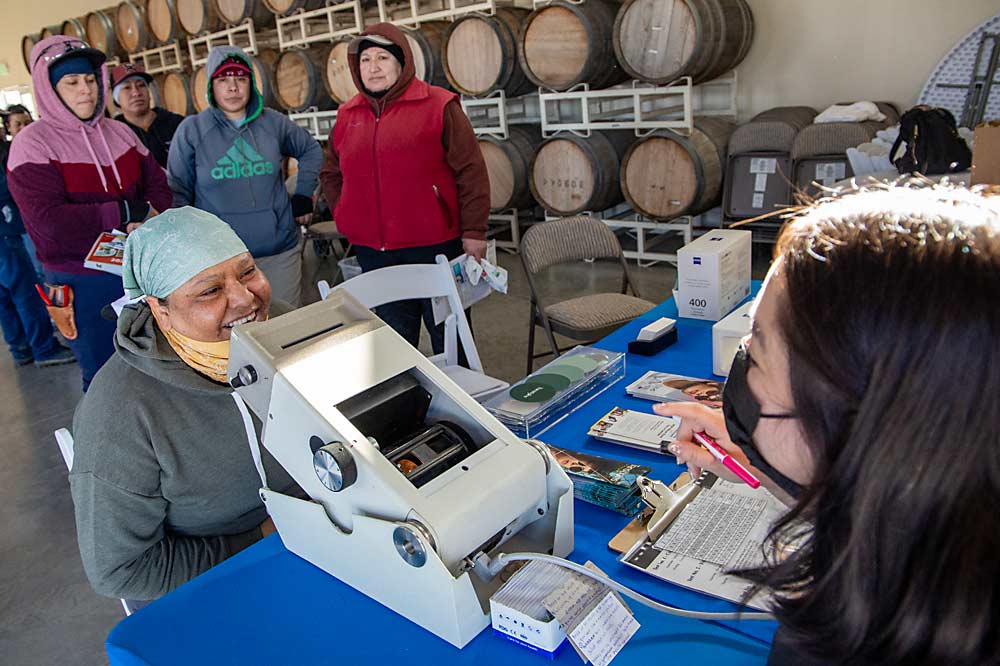 En marzo, durante una feria de la salud en Shaw Vineyards, Benton City, Washington, Briseida Salgado se sometió a una revisión ocular. Estas ferias organizadas por promotoras -especialistas en divulgación comunitaria- son una forma de poner en contacto a los trabajadores agrícolas con servicios esenciales a los que, de otro modo, podrían tener dificultades para acceder por sí mismos. (Ross Courtney/Good Fruit Grower)