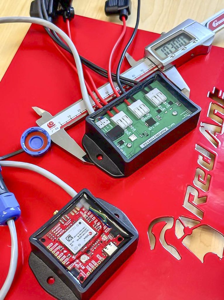 Some orchardists are using small sprayer controllers from South African tech company Red Ant to plug task maps into solenoid valve sprayers for on-off variability. The green box, just 10 centimeters wide, is the controller. The smaller red box at the bottom is an extra antenna for increased location accuracy. (Courtesy Red Ant)