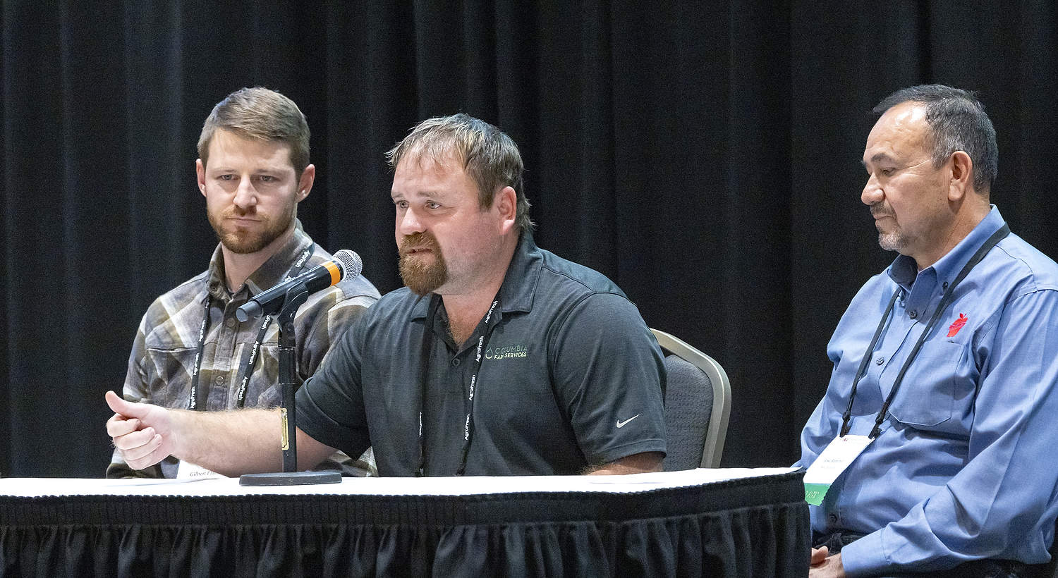 Durante la reunión anual de la Asociación de Productores de Árboles Frutales del Estado de Washington (Washington State Tree Fruit Association), celebrada en diciembre en el Centro de Convenciones de Wenatchee, Adam Zediker, de Columbia Farm Services, habló sobre la importancia de capacitar adecuadamente al personal y tomar decisiones prudentes respecto a las horas extras. En el panel también participaron Gilbert Plath, de Washington Fruit Growers (a la izquierda), y Jose Ramirez, de KS Orchard y El Paraíso Orchard (a la derecha). (Ross Courtney/Good Fruit Grower)