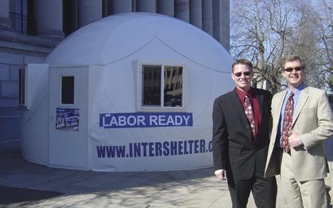Shawn Mattoon of Intershelter, Inc., left, stands with Grant Nelson of the Association of Washington Businesses in front of dome housing assembled on the steps of the Capitol in Olympia, Washington. The dome was on display during Washington Hispanic/Latin