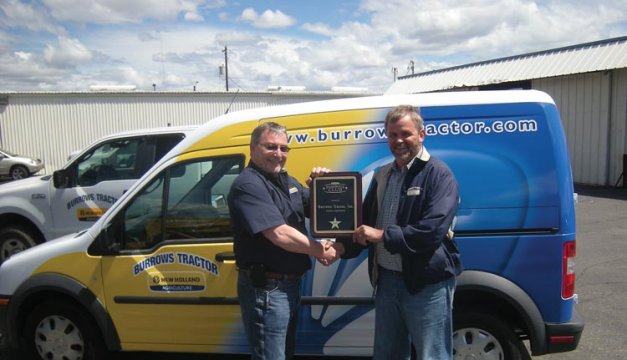Jack Everhart, left, New Holland, Inc., congratulates John Riel, right, of Burrows Tractor.