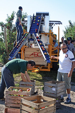 Renfu Lu heads the team that developed the apple harvester/sorter. The demonstration started sorting apples from crates and then moved into the orchard. Photo by Richard Lehnert