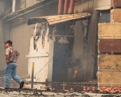 Steve Stewart, Operations Manager at Chelan Fruit Cooperative looks over damage at a warehouse off Highway 150 during the Reach Fire Complex on August 15, 2015 in Chelan, Washington. Mike Bonnicksen/Wenatchee World)