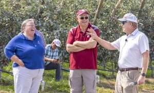 From left, Washington State University’s Karen Lewis and Stefano Musacchi laugh with grower Scott McDougall during a preharvest field day for WA 38 apples in Quincy in 2022. While field days are part of the job for extension specialists, it was Lewis’ repertoire and relationships with growers that served her well throughout her career. (Kate Prengaman/Good Fruit Grower)