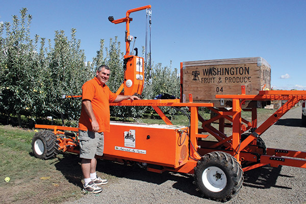 J.J. Dagorret, maker of the Bandit Xpress, checks on a platform in use at an orchard in Othello, Washington.  Photo by Geraldine Warner