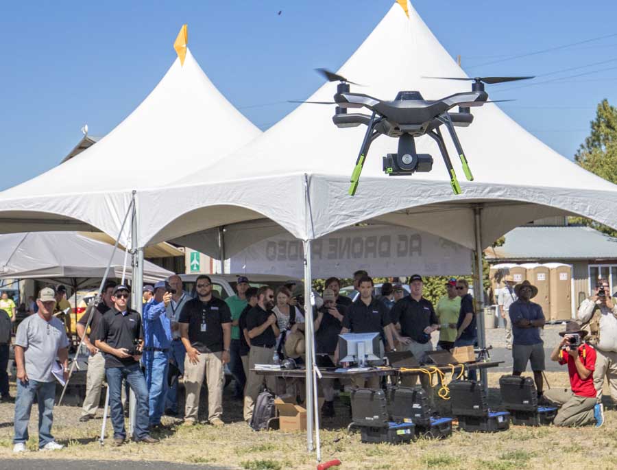 One of three 3DR Solo drones lands in front of spectators. The 3DR drones, equipped with GoPro cameras, were flown together to show how multiple drones could be used together to quickly collect agricultural data from the air. <b>(TJ Mullinax/Good Fruit Grower)</b>