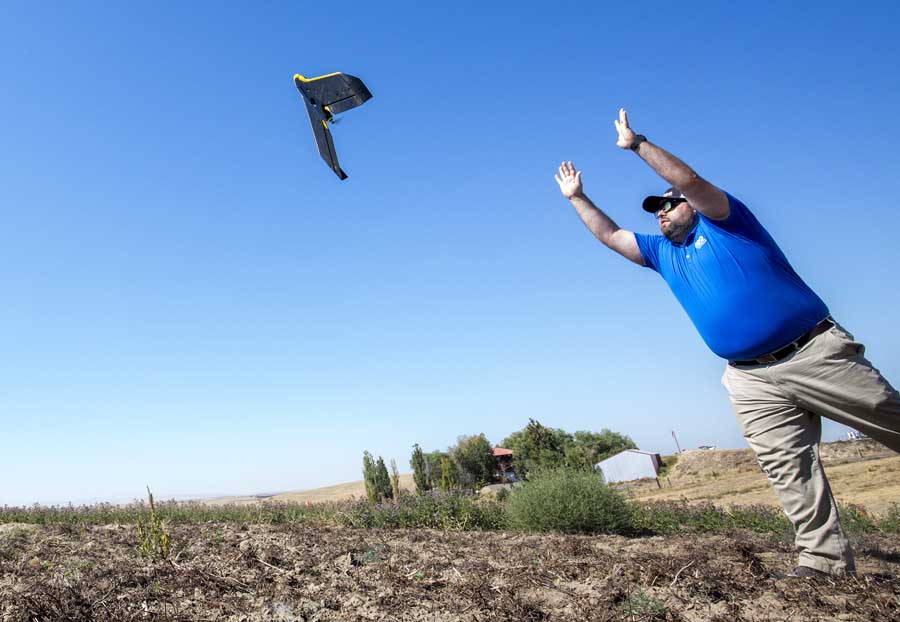 Gary Licquia launches a SenseFly eBee unmanned aerial vehicle, or drone, equipped with a multispectral agricultural sensor during the Ag Drone Rodeo in August in Pendleton, Oregon. Licquia works as a mapping product manager for RDO Integrated Controls, one of several groups demonstrating drones for agricultural use in a field adjoining Linn Airfield. <b>(TJ Mullinax/Good Fruit Grower)</b>