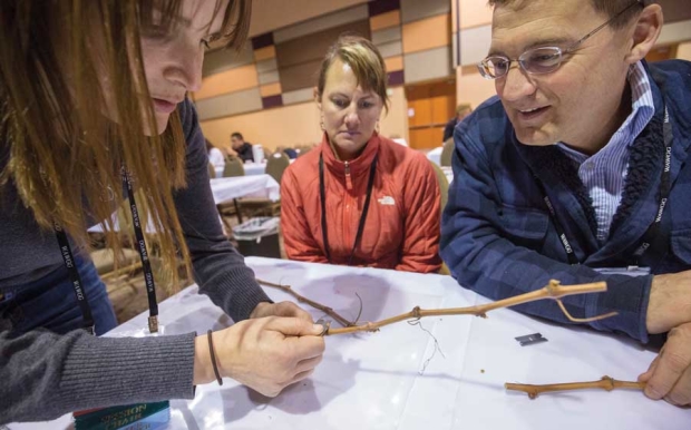 Dr. Michelle Moyer, left, shows Stacy and Greg Letendre how to assess damage to grape buds during the Washington Association of Wine Grape Grower meeting in Kennewick, Wash., on February 11, 2016. Moyer demonstrated a two-cut method of exposing the three buds within the vine during winter. <b>(TJ Mullinax/Good Fruit Grower)</b>