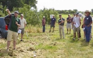Chris Gottschalk, left, of the Michigan State University Department of Horticulture explains the importance of hard cider variety trials as part of a field day at the Clarksville Research Station in south central Lower Michigan. (by Leslie Mertz)