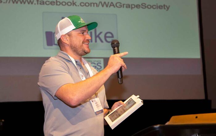 Kevin Judkins of Inland Desert Nursery and Judkins Family Farms gestures toward family members and co-workers as he receives the Grower of the Year Award on Nov. 21 at the Washington State Grape Society Annual Meeting in Grandview. (Ross Courtney/Good Fruit Grower)