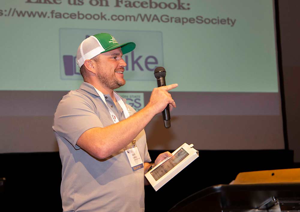 Kevin Judkins of Inland Desert Nursery and Judkins Family Farms gestures toward family members and co-workers as he receives the Grower of the Year Award on Nov. 21 at the Washington State Grape Society Annual Meeting in Grandview. (Ross Courtney/Good Fruit Grower)