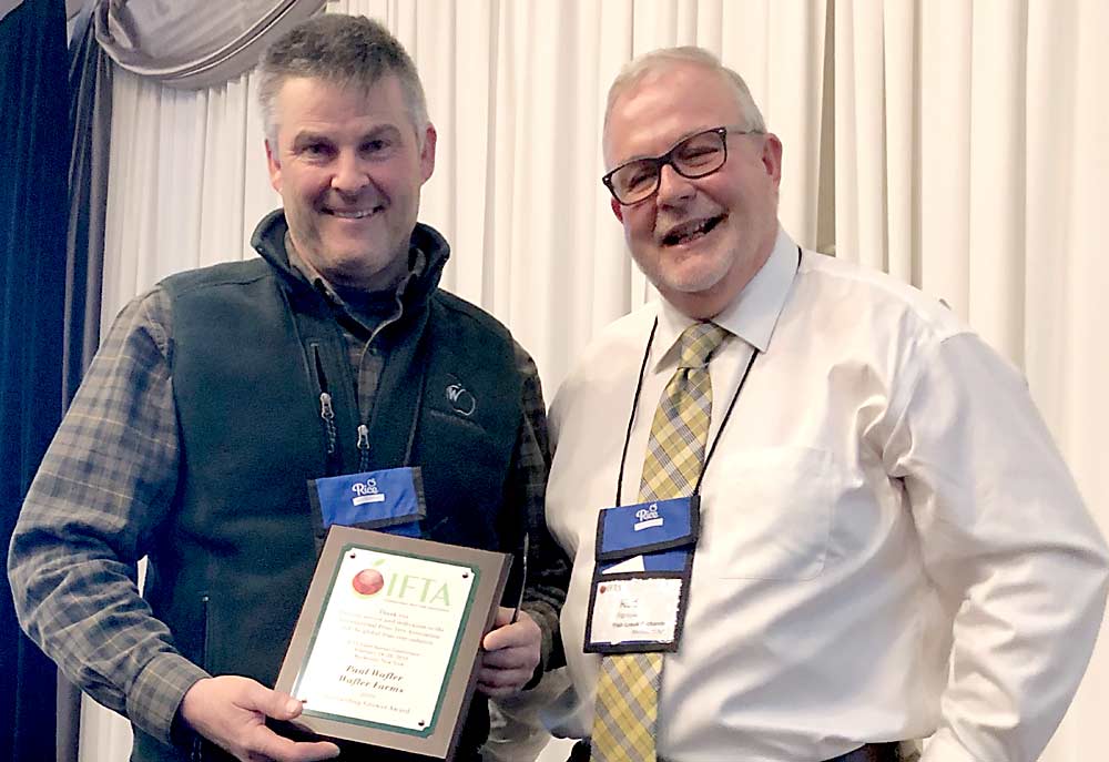 Paul Wafler, left, is presented with the International Fruit Tree Association 2019 Outstanding Grower Award from Rod Farrow, president of the IFTA, on Monday, February 25. (Courtesy Sheri Nolan/IFTA)