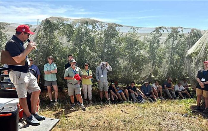 Graeme Krige, left, technical director for the Two-A-Day Group cooperative talks to International Fruit Tree Association tour attendees about the benefits of shade netting for reducing sunburn on apples and pears at Oewerzicht Farm in Greyton, South Africa. (TJ Mullinax/Good Fruit Grower)