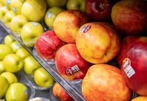 Just a handful of Moxxi apples, a new variety from Stemilt Growers, await buyers in March at Yoke’s Fresh Market in Pasco, Washington. Limited quantities and strategic store placement characterize releases of new cultivars in this depressed apple economy. In the background sits Lemonade apples, a specialty variety from Giumarra. (Ross Courtney/Good Fruit Grower)