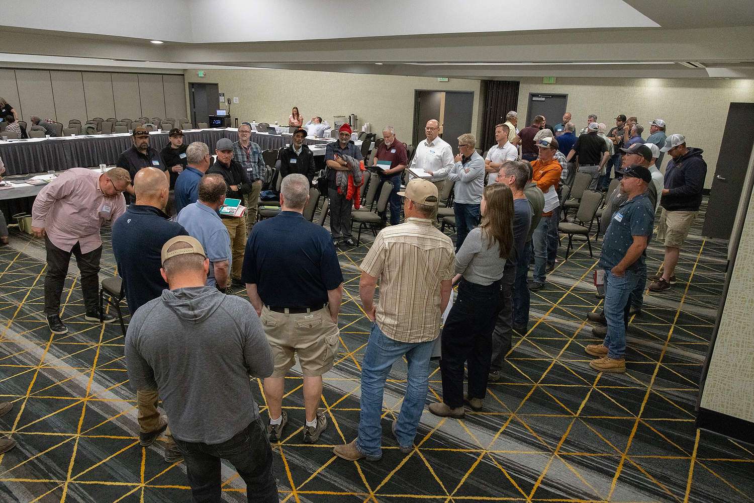Cherry growers and industry representatives huddle in geographical groups to discuss the anticipated size of the 2026 crop at the annual five-state Northwest Cherry Growers meeting on May 13, 2026, in Richland, Washington. They settled on 18.4 million 20-pound box equivalents. (Ross Courtney/Good Fruit Grower)