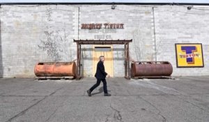 Ed Marquand, organizer of an effort to bring giant mosaic fruit labels to his town of Tieton, Washington, walks in front of a former warehouse showcasing a mosaic of a 1940s Tieton fruit label. (Courtesy Sally Tonkin)
