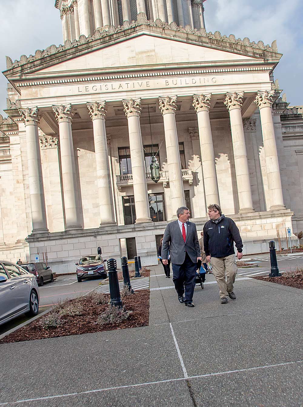 Washington growers Jim Colbert, left, and Mark Hanrahan walk from meeting to meeting in January 2018 at the annual Tree Fruit Day in Olympia. Each year, toward the beginning of the legislative session, industry officials take growers to the state’s Capitol to bend the ear of lawmakers and agency administrators about the tree fruit industry’s concerns. (Ross Courtney/Good Fruit Grower)