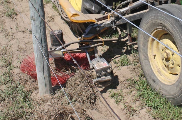 This tractor-mounted rotating brush is used to sweep mounded soil back into the row middle each spring. The buried vine is pulled up first. <b>(Richard Lehnert/Good Fruit Grower)</b>