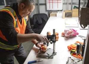 Ryan Morales, a Washington State Department of Agriculture fruit inspector, runs a pressure test on an Envy apple in February at Allan Bros. Fruit in Naches, Washington. (Ross Courtney/Good Fruit Grower)