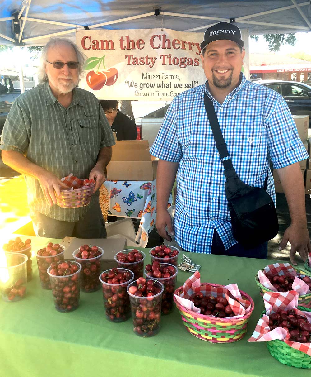 Donald Kaplan, left, and Cam Kaplan of Mirizzi Farms sell their cherries at the Visalia Farmers Market in May. (Photo by Steve Pastis)