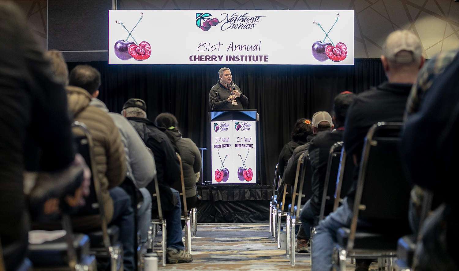 B.J. Thurlby leads the proceedings at the 2024 Cherry Institute in Yakima, Washington. Thurlby has retired after 25 years as president of the Washington State Fruit Commission, which hosts the annual Cherry Institute. (TJ Mullinax/Good Fruit Grower)