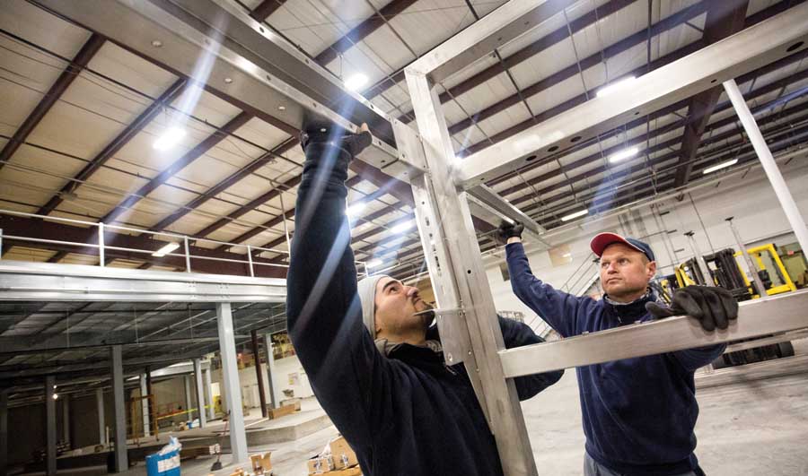 Arnulfo Valdez, left, and Vasile Gado work on the installation at The Dalles Fruit Co. The upgrades will expand capacity to 600 tons per day. <b>(TJ Mullinax/Good Fruit Grower)</b>