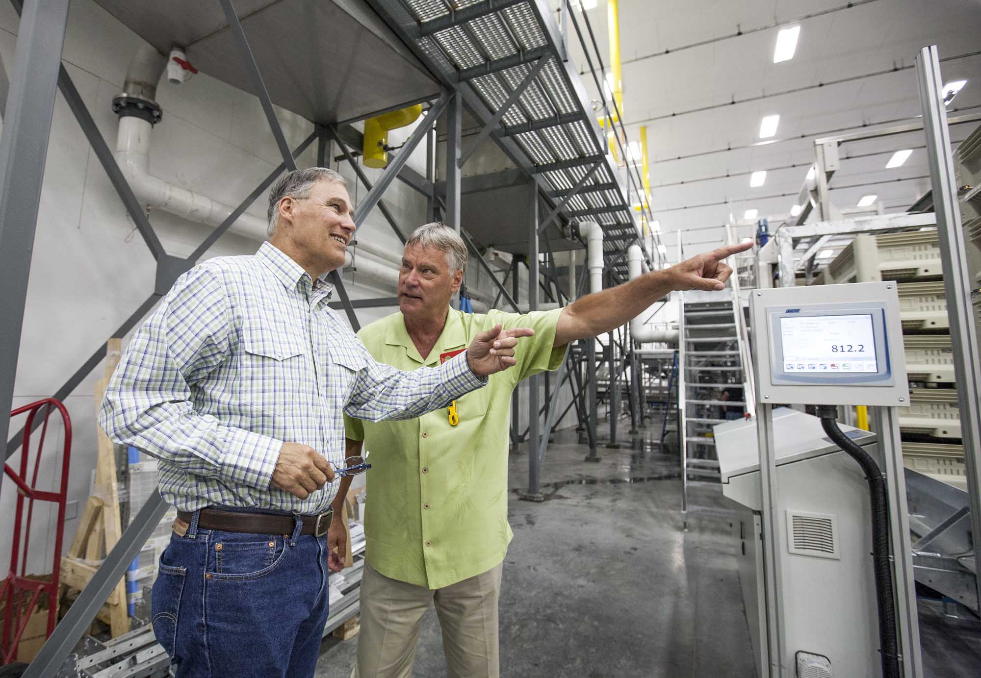 Washington Governor Jay Inslee, left, is given a tour of a new cherry packing line at Washington Fruit and Produce Co. by company president Rick Plath on June 6, 2014, in Yakima, Washington. The state-of-the-art cherry line was in its third full day of operation. (TJ Mullinax/Good Fruit Grower)