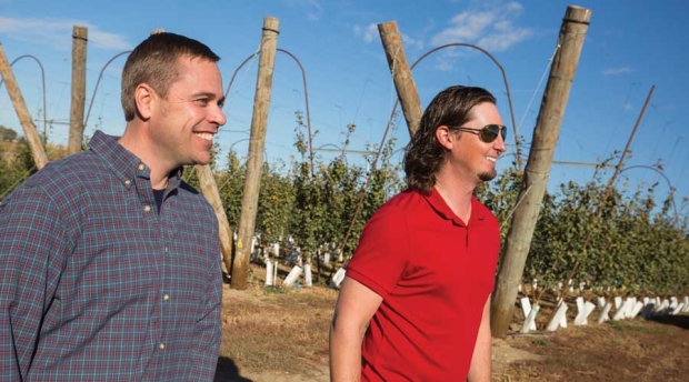 Brenton Roy and Derek Hill walk next to a newly planted block of apples. The large end posts were taken from hops fields. <b>(TJ Mullinax/Good Fruit Grower)</b>