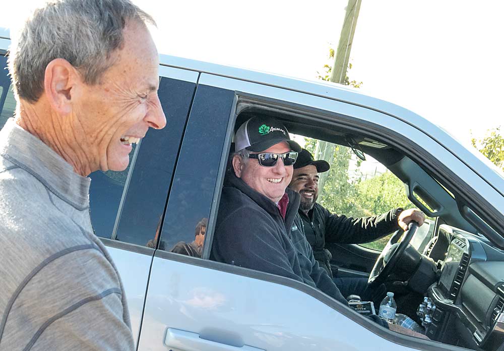 Tom Gausman shares a moment of levity with AgriMACS colleagues Kyle Peer center, and Cesar Ortiz, right, in October at White Alpha Orchard. (TJ Mullinax/Good Fruit Grower)