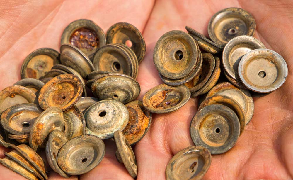 Margaret McCoy, a Washington State University graduate student studying spray technologies, shows a collection of used, rusted disc-core nozzles, the kind often found in a growers’ shop. <b>(Shannon Dininny/Good Fruit Grower)</b>