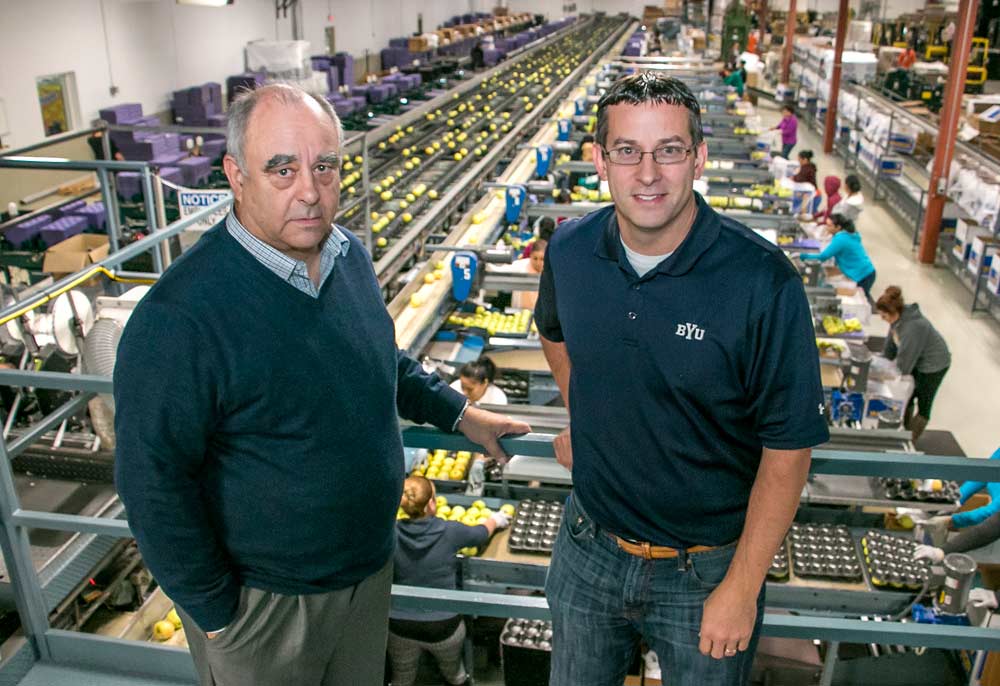 Doug England and his son Jared pose over the packing line at Manson Growers. Doug is the general manager and Jared is the assistant, learning to take the reigns someday. (Ross Courtney/Good Fruit Grower)