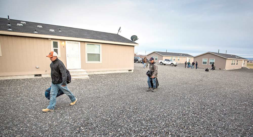 H-2A workers arrive at their housing outside of Royal City, Washington, after the 14 hour bus ride from Tijuana, Mexico, in February 2015. This complex had new facilities with amenities beyond basic housing, including free Wi-Fi, satellite TV and video game systems. <b> (TJ Mullinax/Good Fruit Grower)</b>