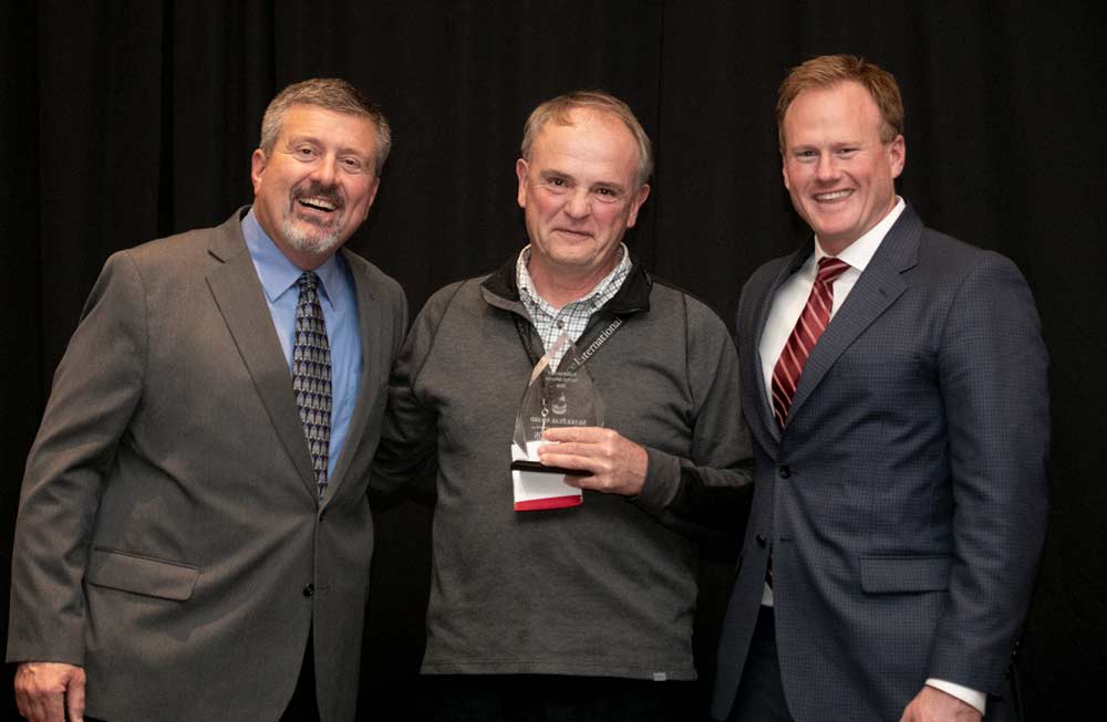 Ken Johnson from Oregon State University, center, receives the Silver Pear Award during the Washington State Tree Fruit Association's award banquet on Tuesday, December 4, 2018, at the Yakima Convention Center in Yakima, Washington. (TJ Mullinax/Good Fruit Grower)