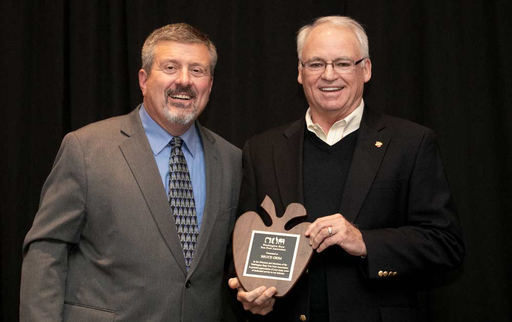 Bruce Grim, right, receives a Special Recognition Award during the Washington State Tree Fruit Association's award banquet on Tuesday, December 4, 2018, at the Yakima Convention Center in Yakima, Washington. (TJ Mullinax/Good Fruit Grower)