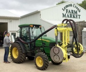 A Collard pneumatic leaf remover, shown here mounted to the front of a tractor and used in the MSU study, has spinning air compressors that shred grape leaves on both sides as it moves down the row. (Photo courtesy of Josh VanderWeide)