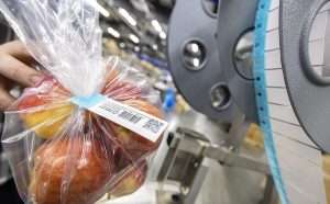 A Kwik Lok labeling machine that can print custom QR and UPC barcodes on bag closure labels at the company’s Yakima, Washington, facility in December. The company debuted the machine and its labels at the 2025 International Fresh Produce Association show in October. (TJ Mullinax/Good Fruit Grower illustration)