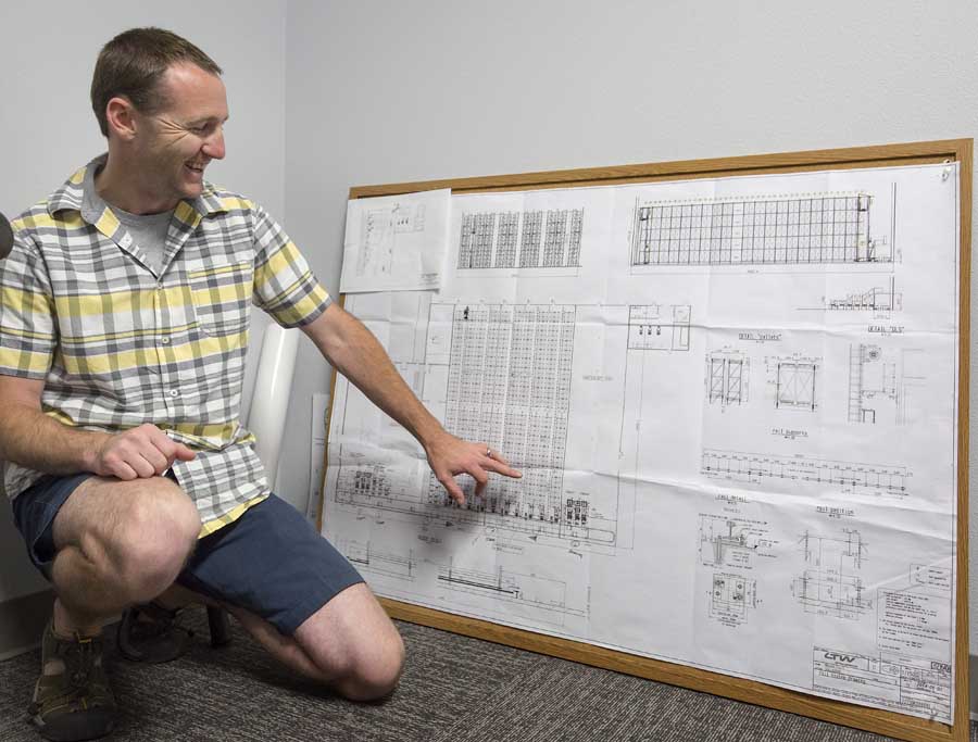 Jordan Matson shows the architectural plans for the Matson automated cold storage facility in August 2016. <b>(TJ Mullinax/Good Fruit Grower)</b>
