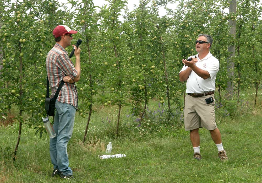 Cornell’s Jaume Lordan and Mario Miranda Sazo discuss the importance of irrigation in high density apple plantings on the Lake Ontario Fruit Summer Tour. <b>(Kate Prengaman/Good Fruit Grower)</b>