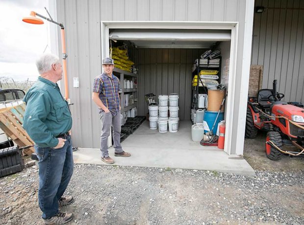 Sullivan shows Long his organized and well-labeled chemical shed, as part of the organic inspection. (TJ Mullinax/Good Fruit Grower)