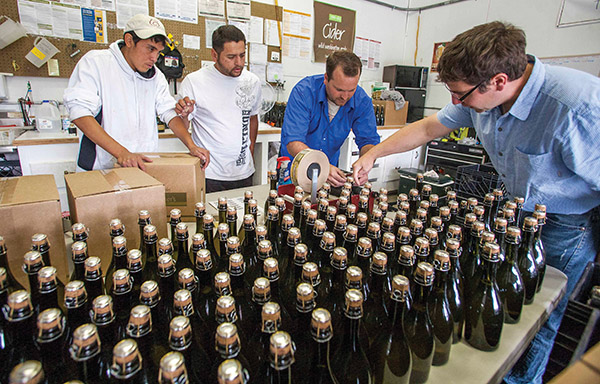 From left, Carlos Gutierrez, Salvador Sanchez, Robert McCurdy, and Marcus Robert prep bottles.  Photo by TJ Mullinax