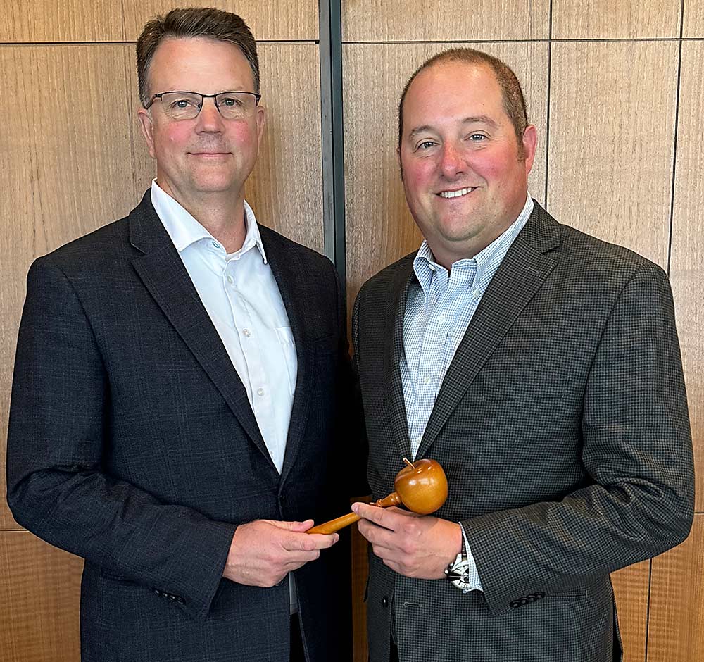 Immediate Past Chair Steve Clement, left, hands the gavel to Brett Baker, the new chair of the U.S. Apple Association’s board of directors. (Courtesy U.S. Apple Association)