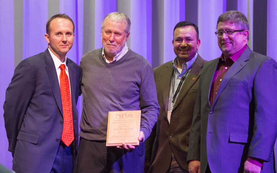Jay Brunner is presented with a Distinguished Service Award during the 112th Annual Meeting and Northwest Hort Expo banquet on December 6, 2016 in Wenatchee, Washington. From left, West Mathisson, Brunner, José Ramirez and Sam Godwin. <b>(TJ Mullinax/Good Fruit Grower)</b>