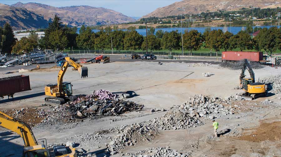 Workers break up concrete from a Blue Bird Inc. warehouse that was destroyed by a wildfire to prepare the site for construction in Wenatchee, Washington on September 9, 2015. <b> (Shannon Dininny/Good Fruit Grower)</b>
