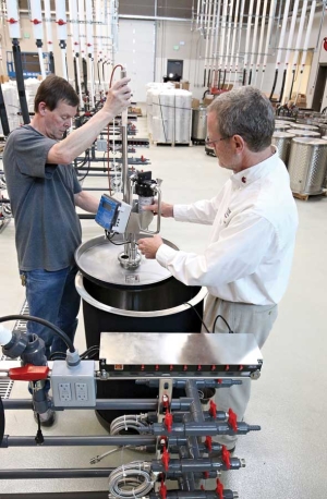 Washington State University research winemaker Richard Larsen, left, and Thomas Henick-Kling temporarily ssembles a state-of-the-art fermentation system in the center’s winery. The system includes automatic pumps for pump-overs. (TJ Mullinax/Good Fruit Grower)